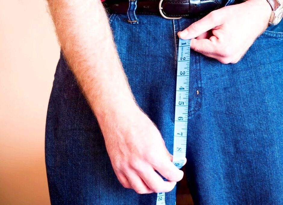 man measures penis after enlargement